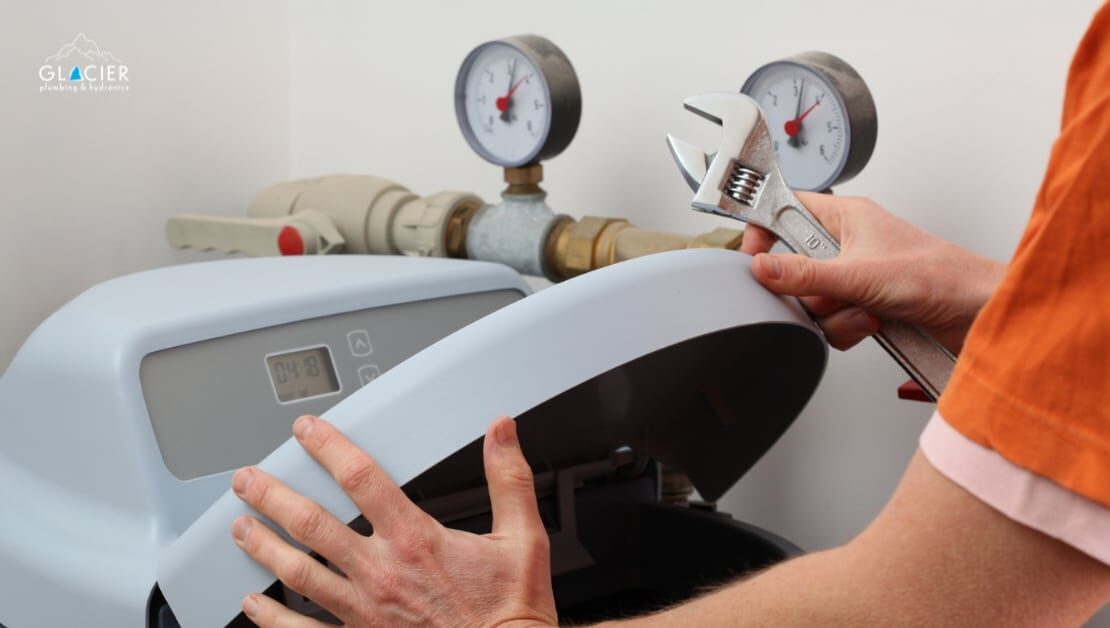 Plumber repairing a water softener system in a home utility room