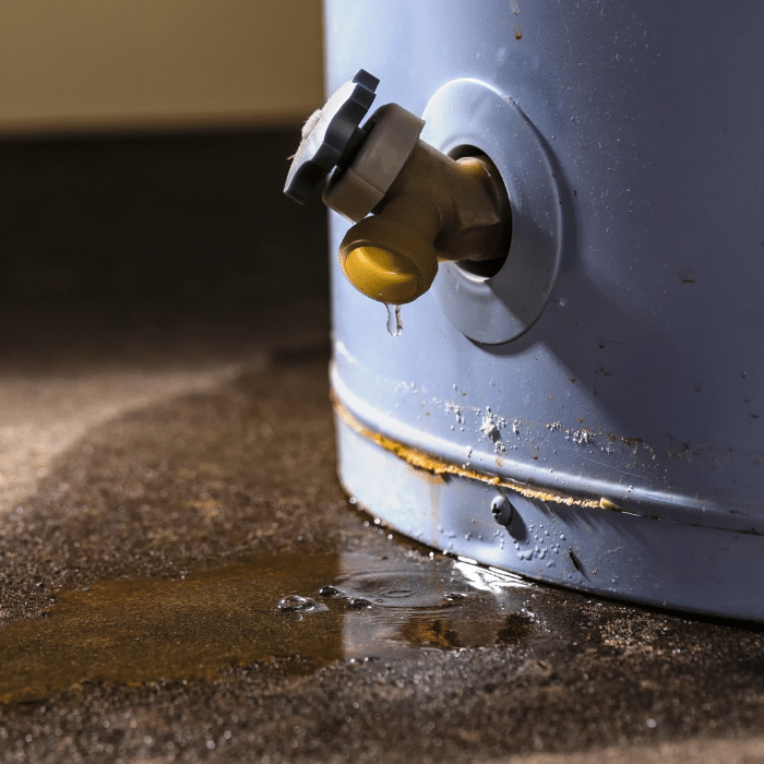 A leaking valve at the bottom of a water heater, with water pooling on the ground and signs of rust around the base, may signal urgent need for Water Heater Repair.